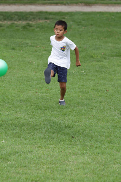 istock Japanese boy playing with soccer ball (second grade at elementary school) 824827568