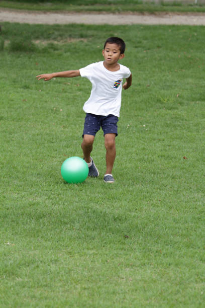 istock Japanese boy playing with soccer ball (second grade at elementary school) 824827710