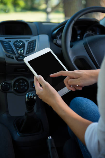 istock Woman using digital tablet in the car 824827928