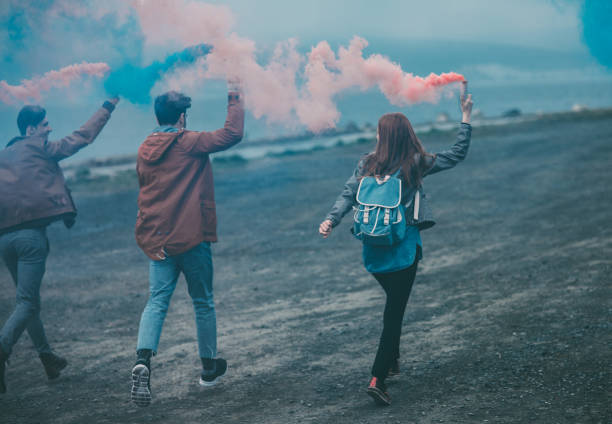 istock Friends running with smoke bombs in their hands 824832374