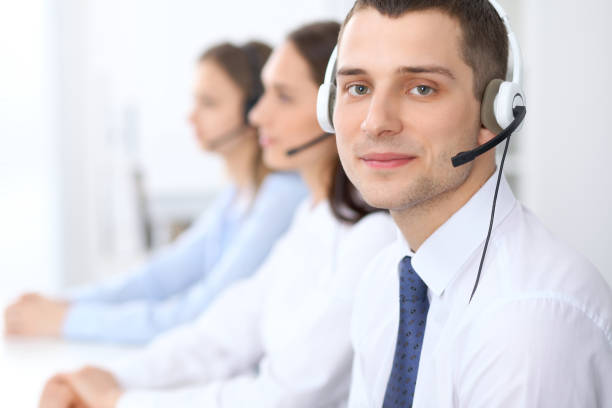 istock Call center operators. Focus at businessman in headset while consulting customers 824832580
