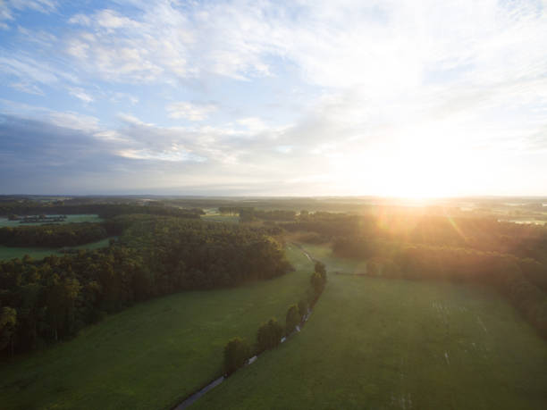 istock Aerial view of a beautiful sunset over forest landscape with green fields 824841476