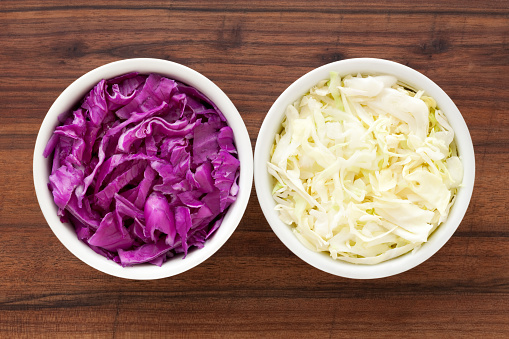 Top view of two bowls with regular and red cabbage for contrast concept