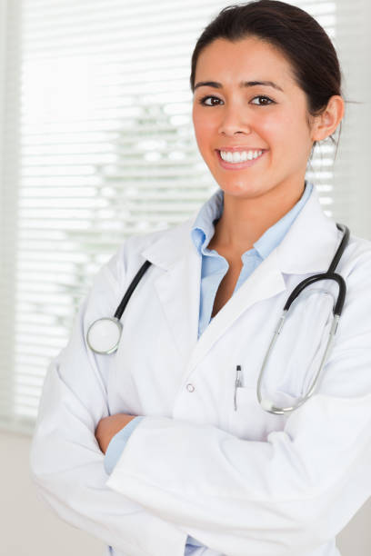 istock Lovely female doctor with a stethoscope posing while standing 824852866