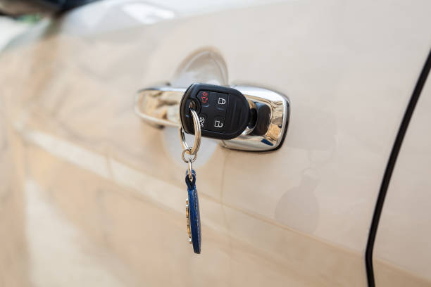 llave del vehículo está insertado en la puerta de coche que color es el blanco, cerca de la llave del vehículo en el coche - car car door door handle fotografías e imágenes de stock