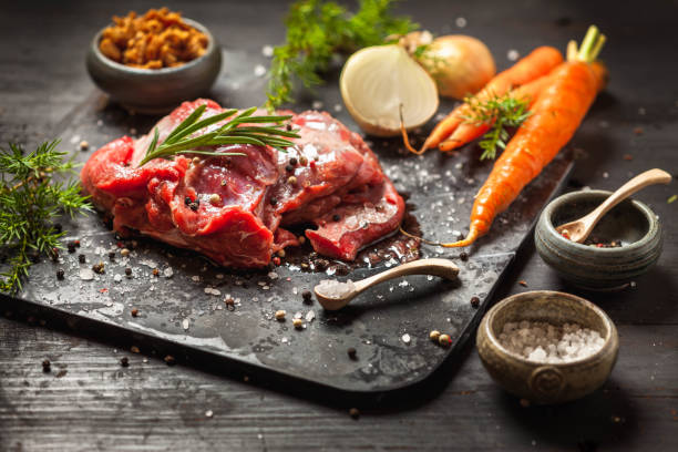Deer or venison roast Deer or venison roast, traditional finnish food, rosvopaisti, with Chanterelle fungus, Sea salt, red, green, white pepper and coriander in clay pots on an old black rustic table. juniperus chinensis stock pictures, royalty-free photos & images