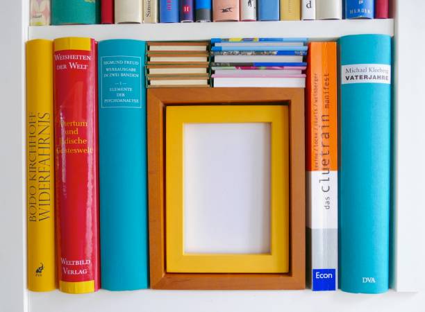 scaffale di libri riempiti da vicino con una cornice vuota gialla marrone: spazio per la copia - book book spine in a row library foto e immagini stock