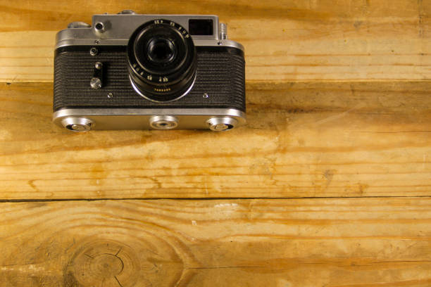 istock Retro photo camera on old wooden background 824864786