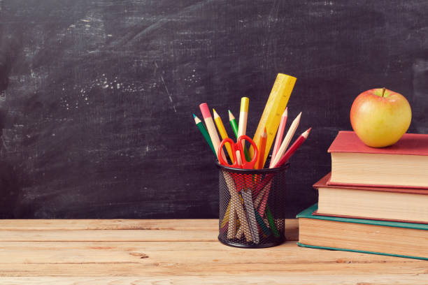 istock Back to school background with books, pencils and apple over chalkboard 824864970