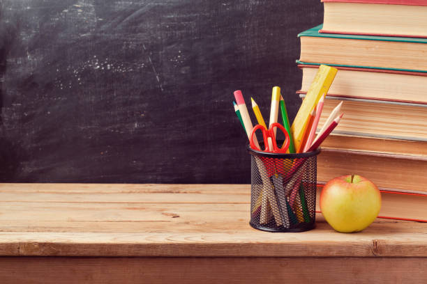 istock Back to school background with books, pencils and apple over chalkboard 824865002