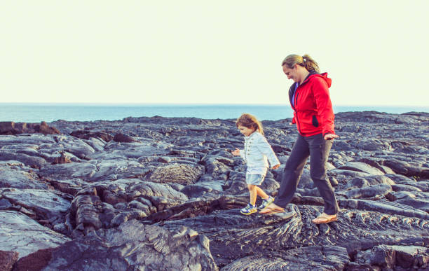 Child and mom explore Volcano Field, Volcano national park Barren land in Volcanoes national park, lava field, child explores the landscape with her mother hawaii volcanoes national park photos stock pictures, royalty-free photos & images
