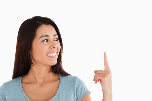 istock Portrait of a beautiful woman pointing at a copy space while standing 824868530