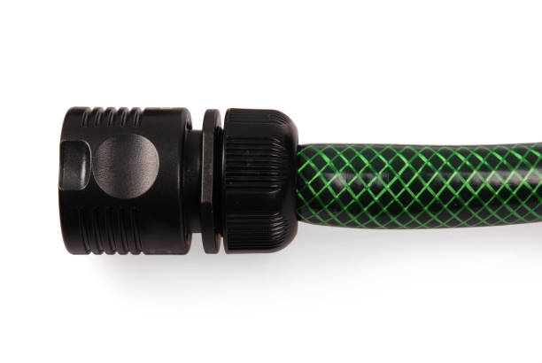 Green garden water hose and black nozzle, isolated on white background with soft shadow. Photo with clipping path
