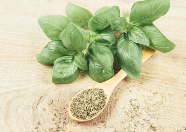 istock Raw green basil and dried, on the wooden table. 824870898
