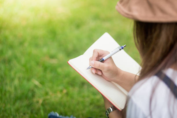 istock A girl write down in the book in park 824880468