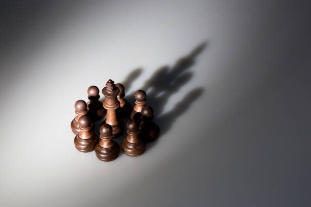 istock shadow of chess pieces lokk like a king crown 824880744