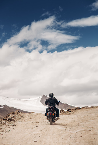 Viajero solitario motocyclist en rosad de montaña en Himalaya photo