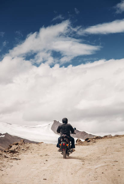 Lonely motocyclist traveler on mountain rosad in Himalaya Lonely motocyclist traveler on mountain rosad in Himalaya leh district stock pictures, royalty-free photos & images