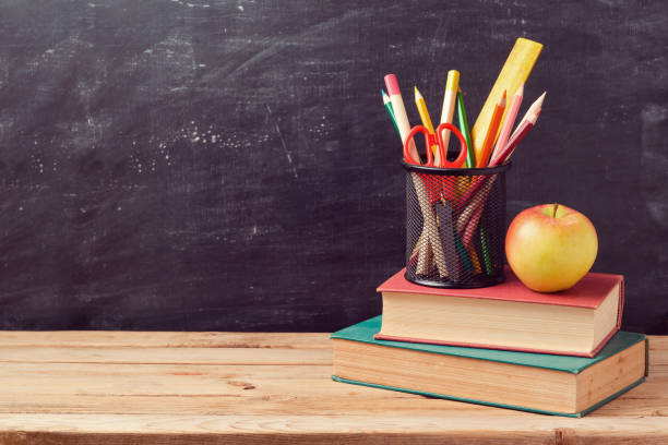 istock Back to school background with books, pencils and apple over chalkboard 824907324