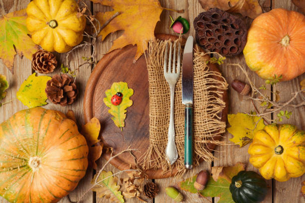 istock Autumn background with fall leaves and pumpkin over wooden table. View from above 824907378