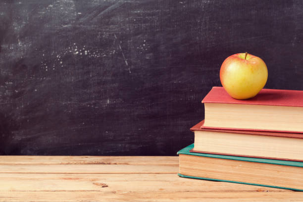 istock Back to school background with books and apple over chalkboard 824907384