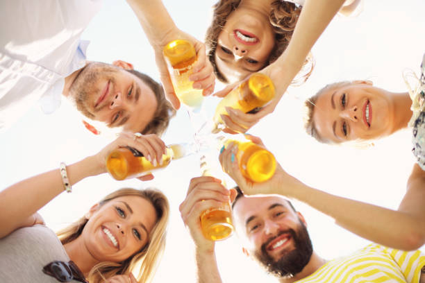 istock Group of young people cheering and having fun outdoors with drinks 824910678