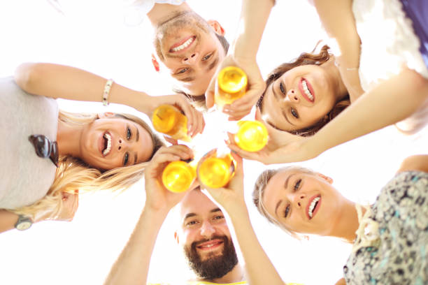istock Group of young people cheering and having fun outdoors with drinks 824913208