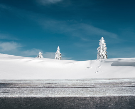 Winter background: Empty wooden planks with defocused winter landscape.