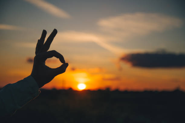 istock hands show ok sign on sunset 824920390