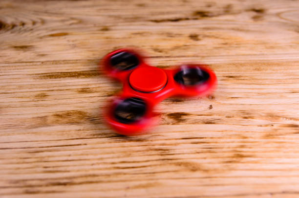 istock Red spinning toy rotates on wooden desk 824920578