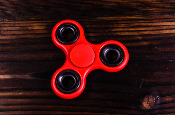 istock Red spinning toy on wooden desk. Top view 824920594