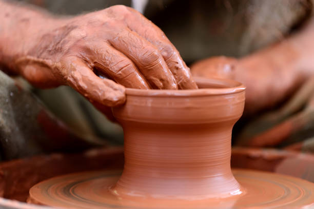 istock Potter making ceramic pot on the pottery wheel 824925052