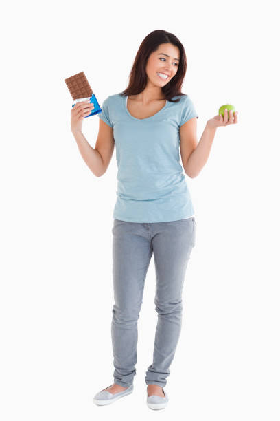 Health Benefits Versus Harms. An apple and chocolate bar comparing health benefits and harms.