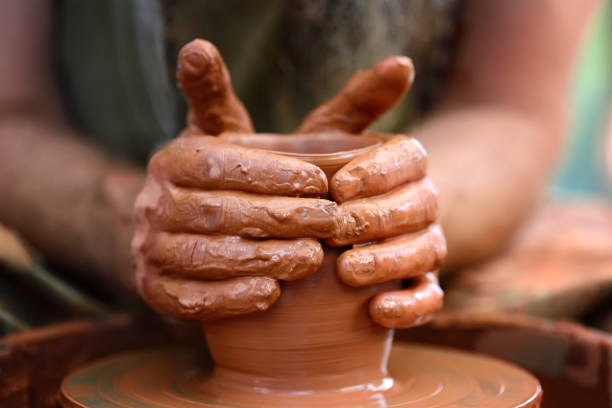 istock Potter making ceramic pot on the pottery wheel 824925094