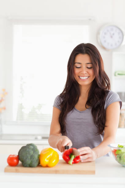 istock Good looking woman cooking vegetables while standing 824927360
