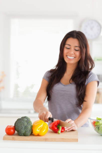 istock Lovely woman cooking vegetables while standing 824927704