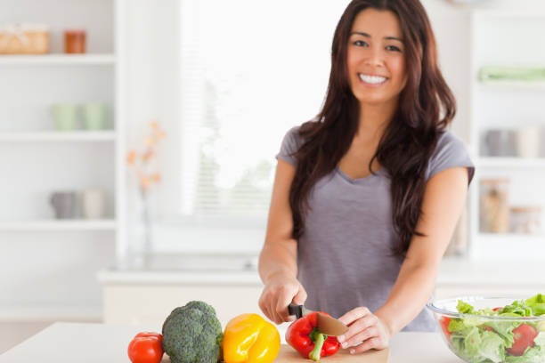 istock Gorgeous woman cooking vegetables while standing 824927716