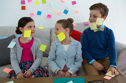 Kids as business executives playing with sticky notes in office