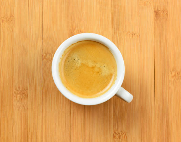 istock White cup of hot espresso coffee on wood table, background 824931254
