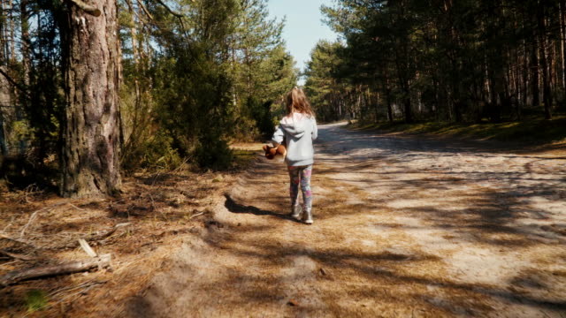 girl walks on a forest road in summer