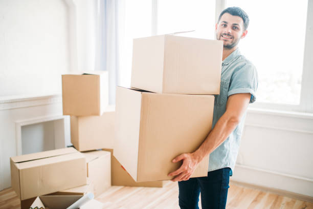 istock Man holds boxes in hands, moving to new house 824934680