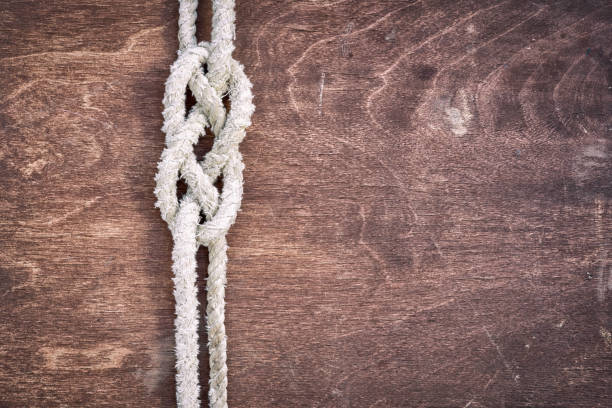 White rope tied in a knot and wood plank for adventure.