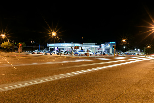 Perth, Australia - December 22, 2015: Mazda car dealership Bayswater by night. At the intersection Garratt Road Guildford Road in Bayswater. Light trails from traffic on the Guildford Road. Western Australia, Perth, Bayswater