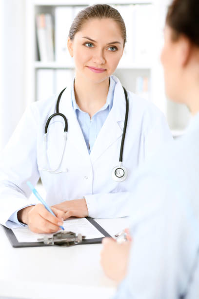istock Friendly smiling doctor  and  patient sitting at the table 824943136