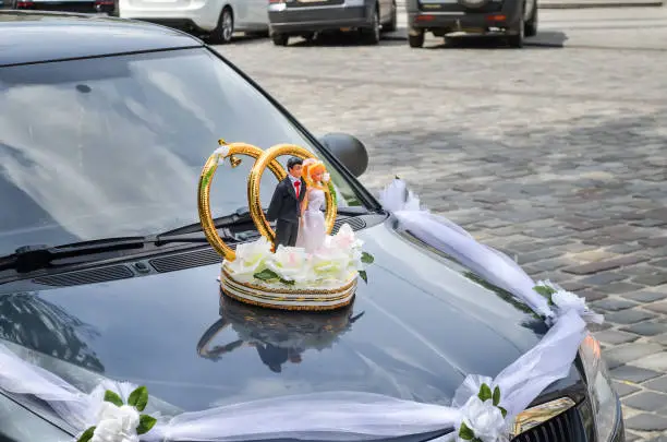 Wedding decoration on car with bride and groom