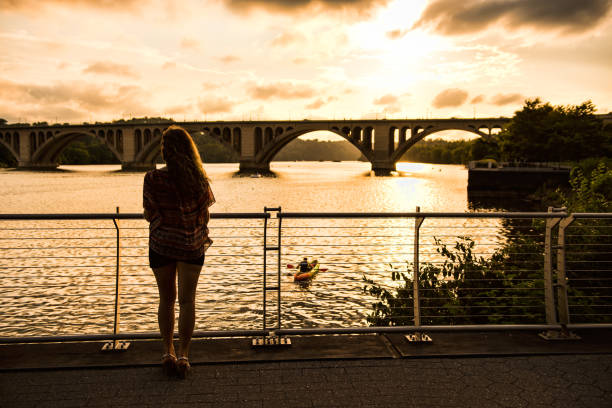 kuvapankkikuvat ja rojaltivapaat kuvat aiheesta takana nuori nainen katsellen potomac-joen yli francis scott key bridgen kanssa auringonlaskun aikana - rosslyn virginia