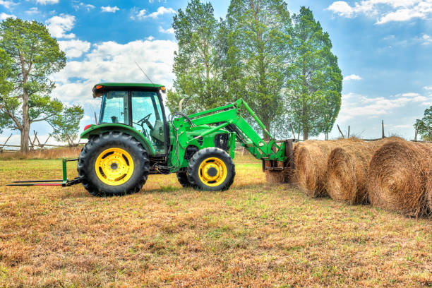 istock Hay roll bales with tractor on countryside field 824952530