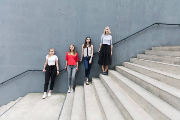 istock Young women standing on stairs by concrete wall 824955696