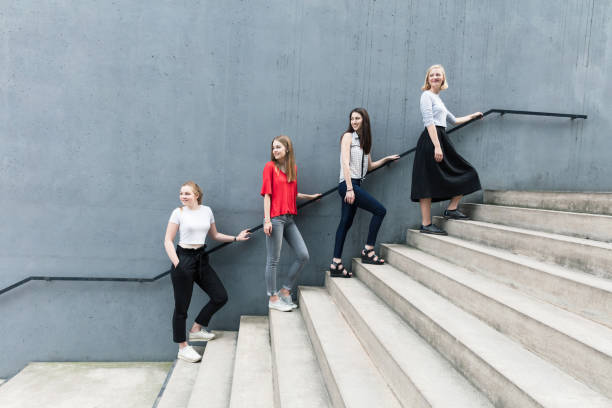 istock Young women standing on stairs by concrete wall 824956090