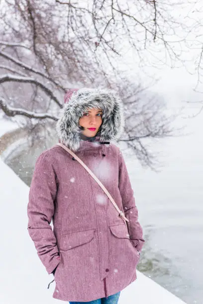 Young woman in winter coat walking along Tidal basin path during snow storm in Washington DC